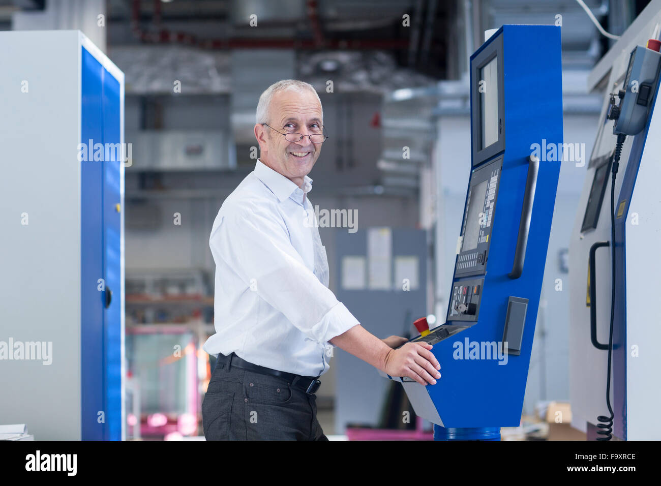 Porträt von lächelnden Mann auf der Control in einer Industriehalle Stockfoto