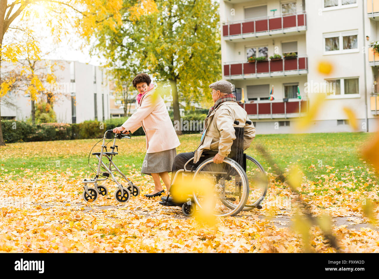 Ältere Frau mit Rädern Walker und senior Mann im Rollstuhl im Freien im Herbst Stockfoto