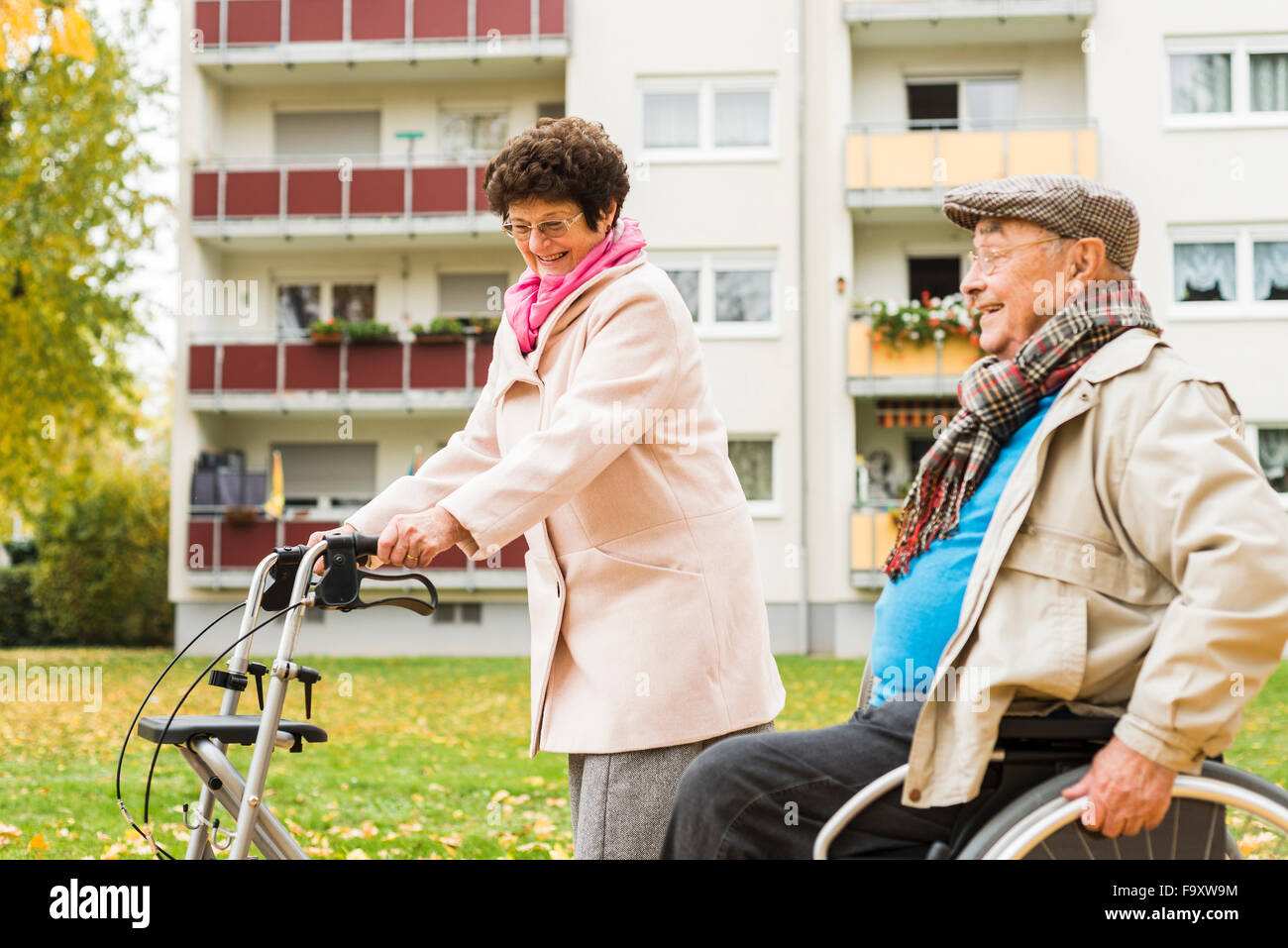 Ältere Frau mit Rädern Walker und senior Mann im Rollstuhl im Freien im Herbst Stockfoto