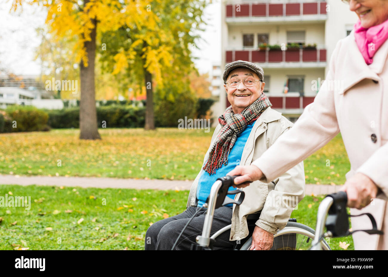 Ältere Frau mit Rädern Walker und senior Mann im Rollstuhl im Freien im Herbst Stockfoto