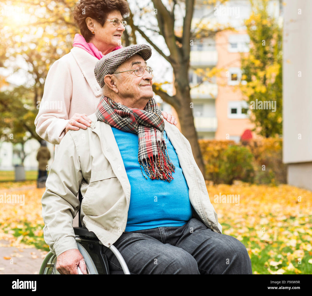 Ältere Frau mit Mann im Rollstuhl im freien Stockfoto