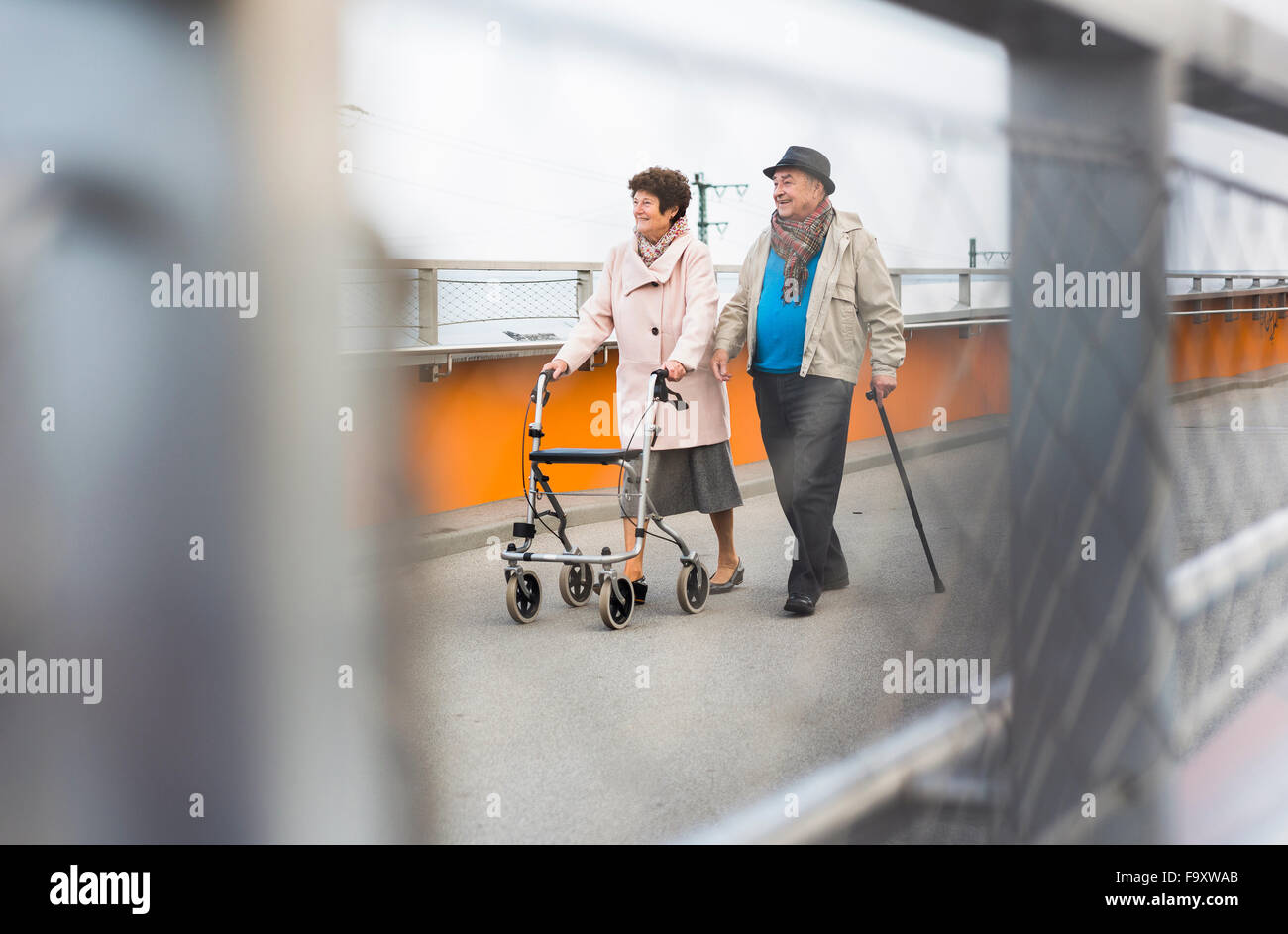 Älteres paar walking mit Gehstock und Walker auf Rädern Stockfoto