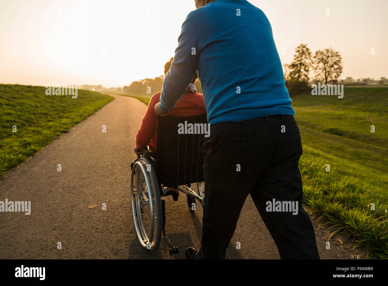 Ältere Mann schob Frau im Rollstuhl in der Natur Stockfoto