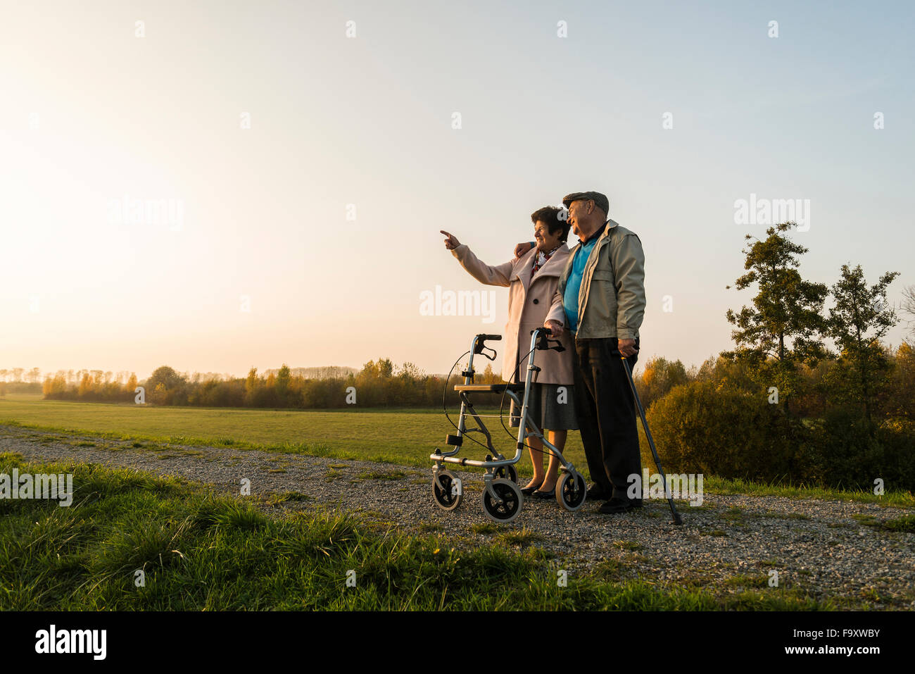 Älteres Paar mit Gehstock und Rädern Walker stehen in der Natur Stockfoto