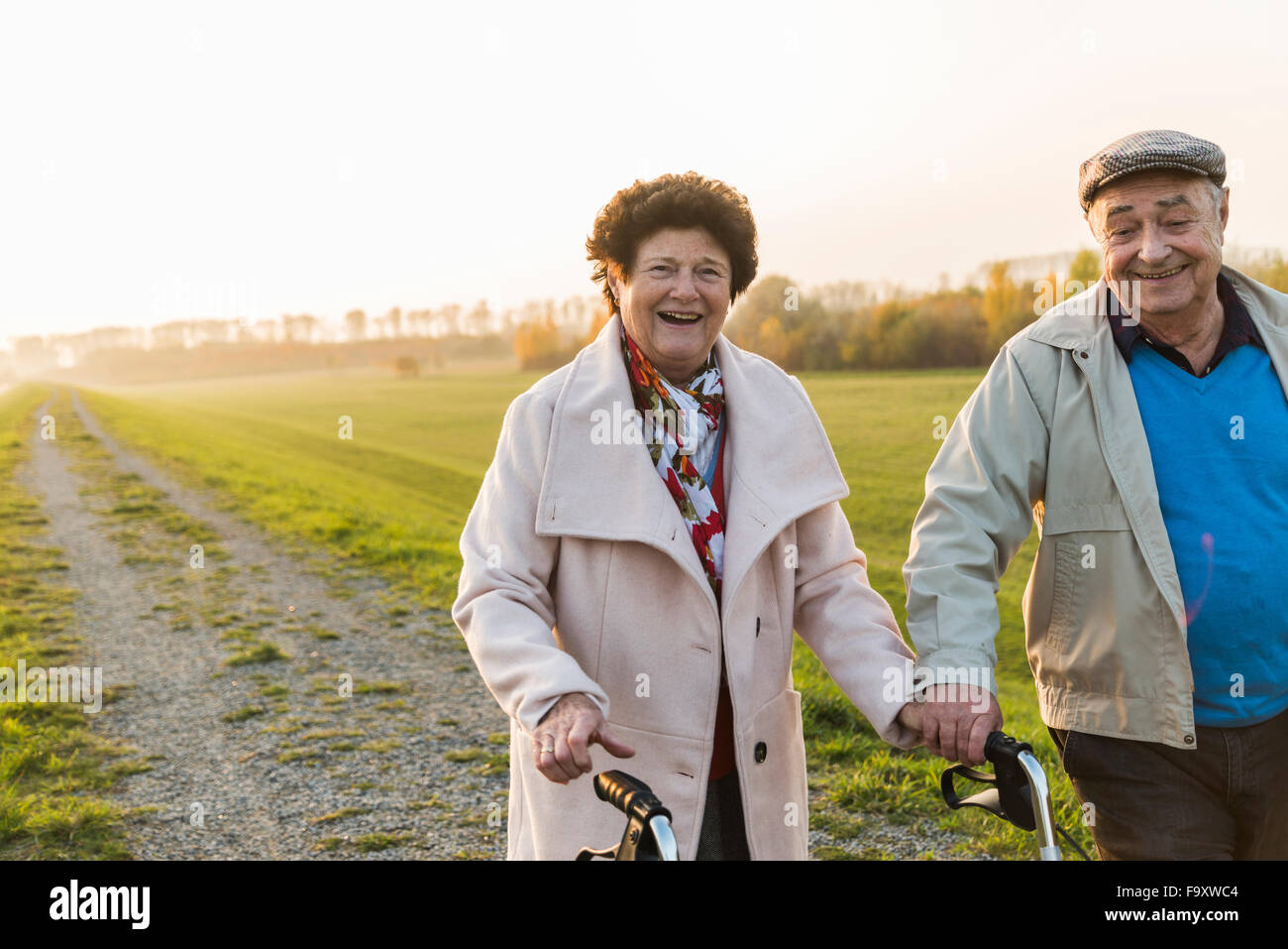 Lächelnd älteres Paar mit Rädern Walker in der Natur Stockfoto