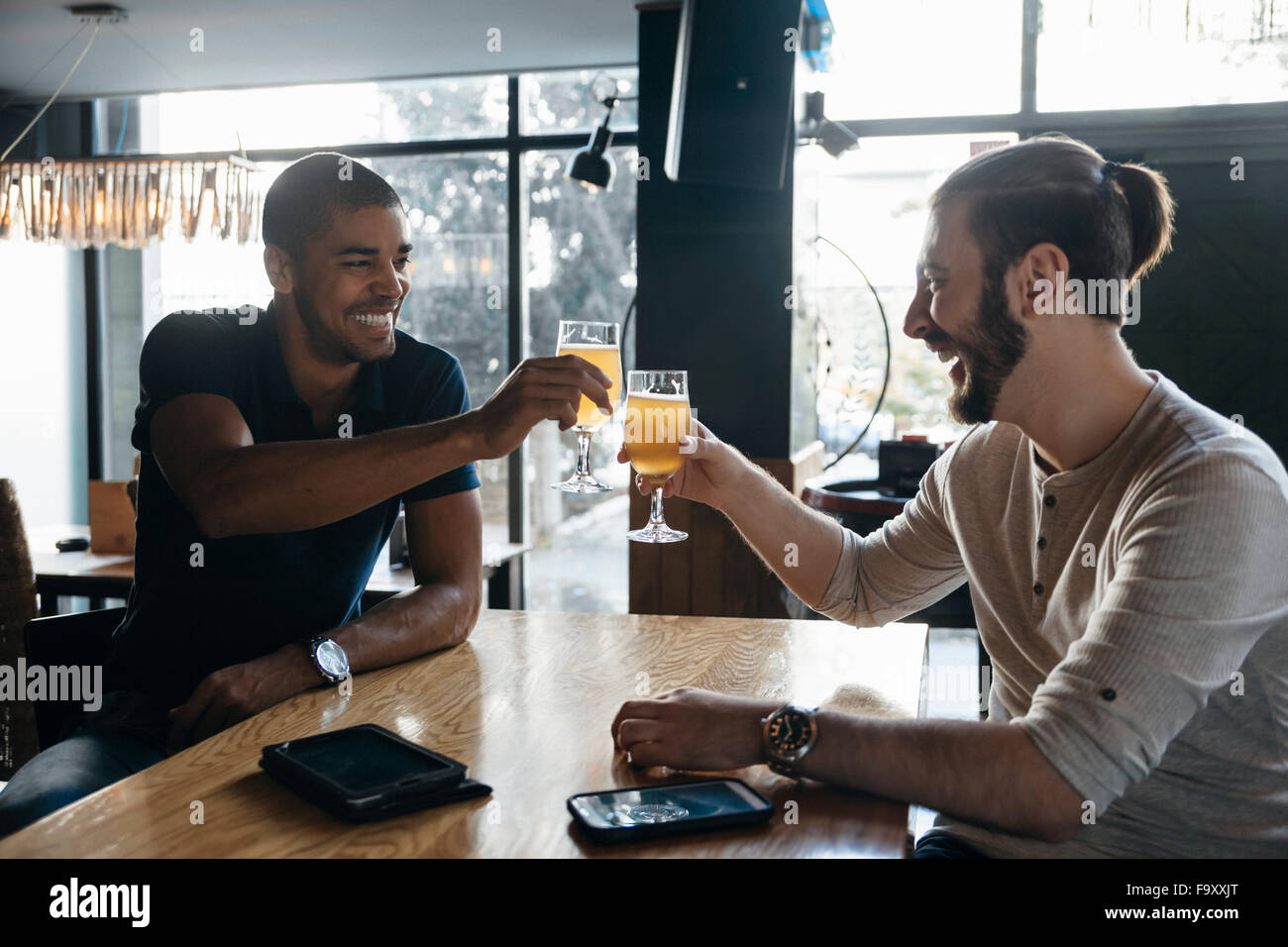 Zwei glückliche Männer in einer Bar klirrendes Biergläser Stockfoto