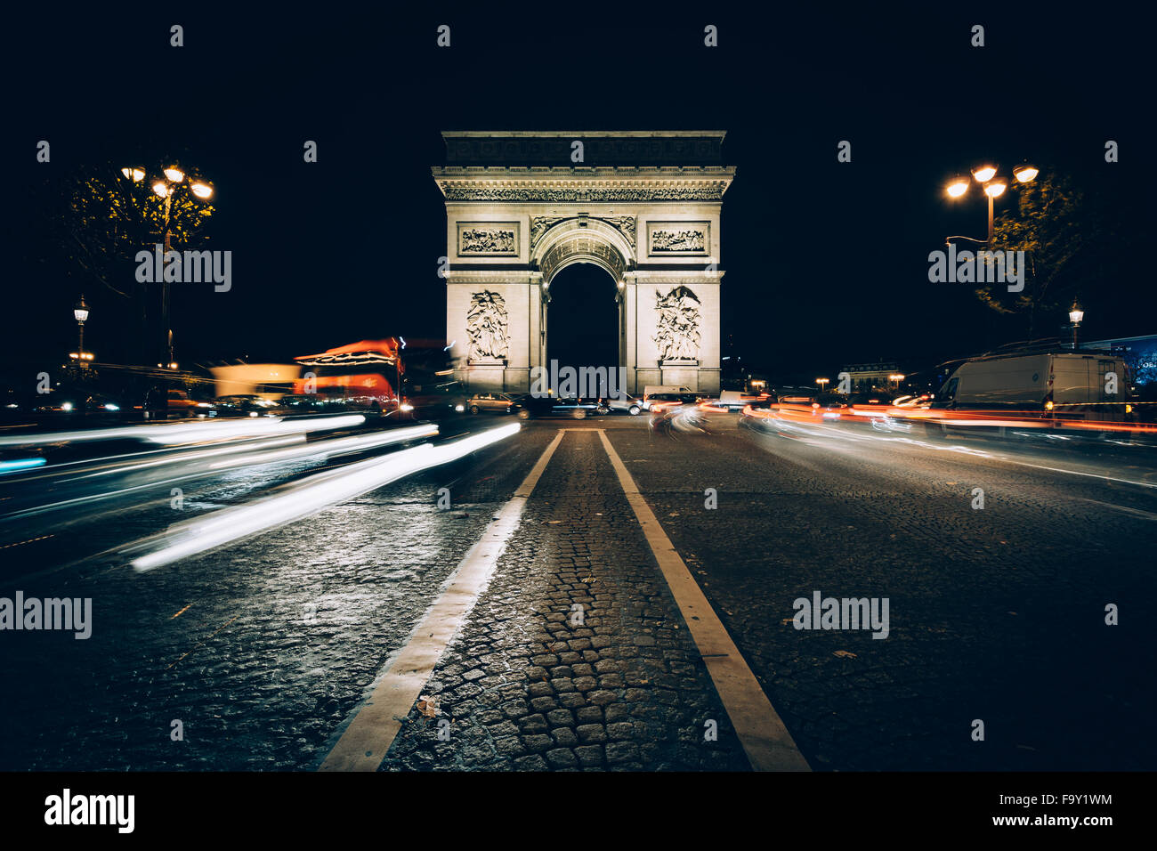 Verkehr auf der Avenue des Champs-Élysées und Arc de Triomphe nachts in Paris, Frankreich. Stockfoto