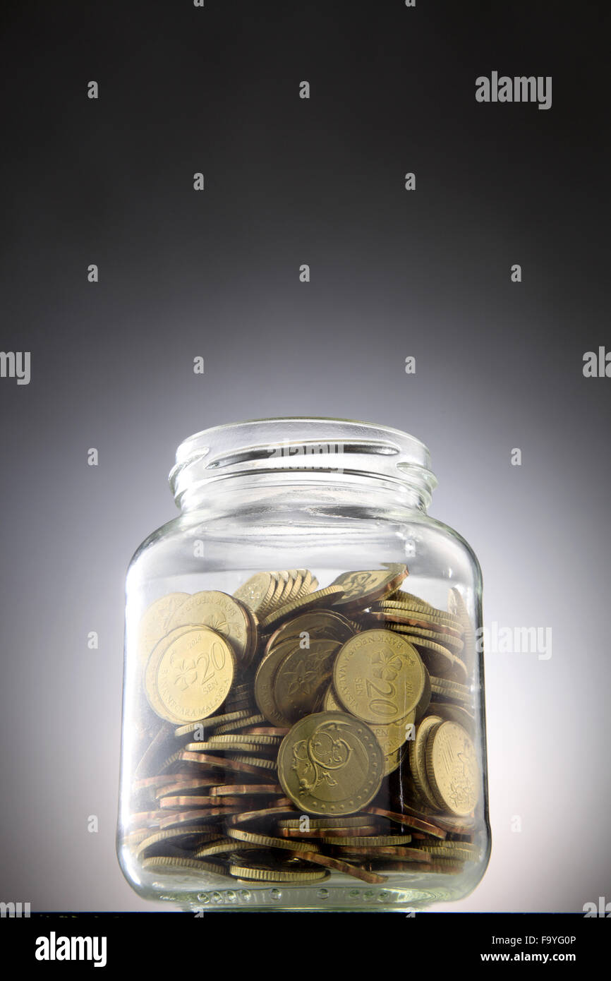 Geld oder Münzen in das rettende Glas Stockfoto