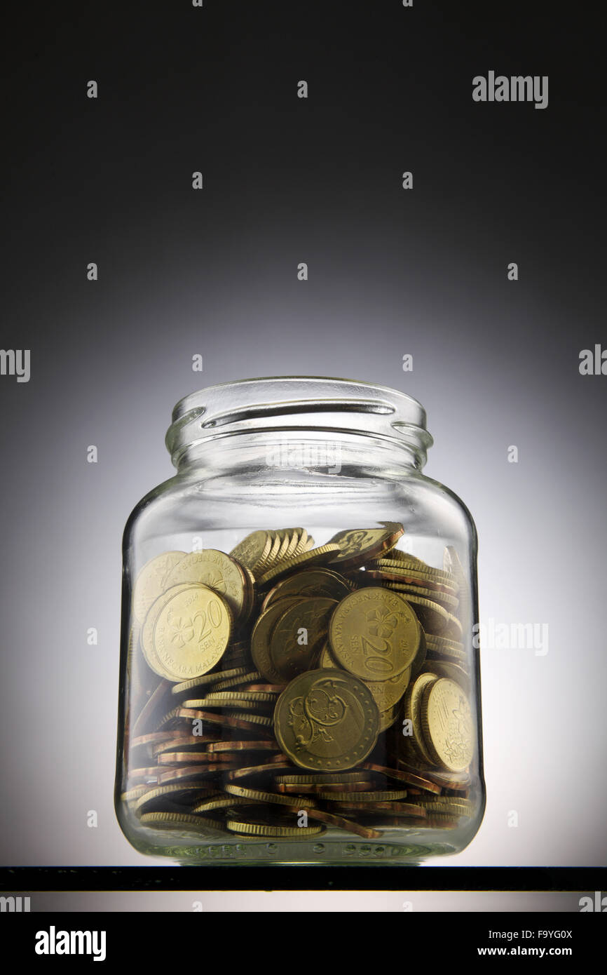 Geld oder Münzen in das rettende Glas Stockfoto