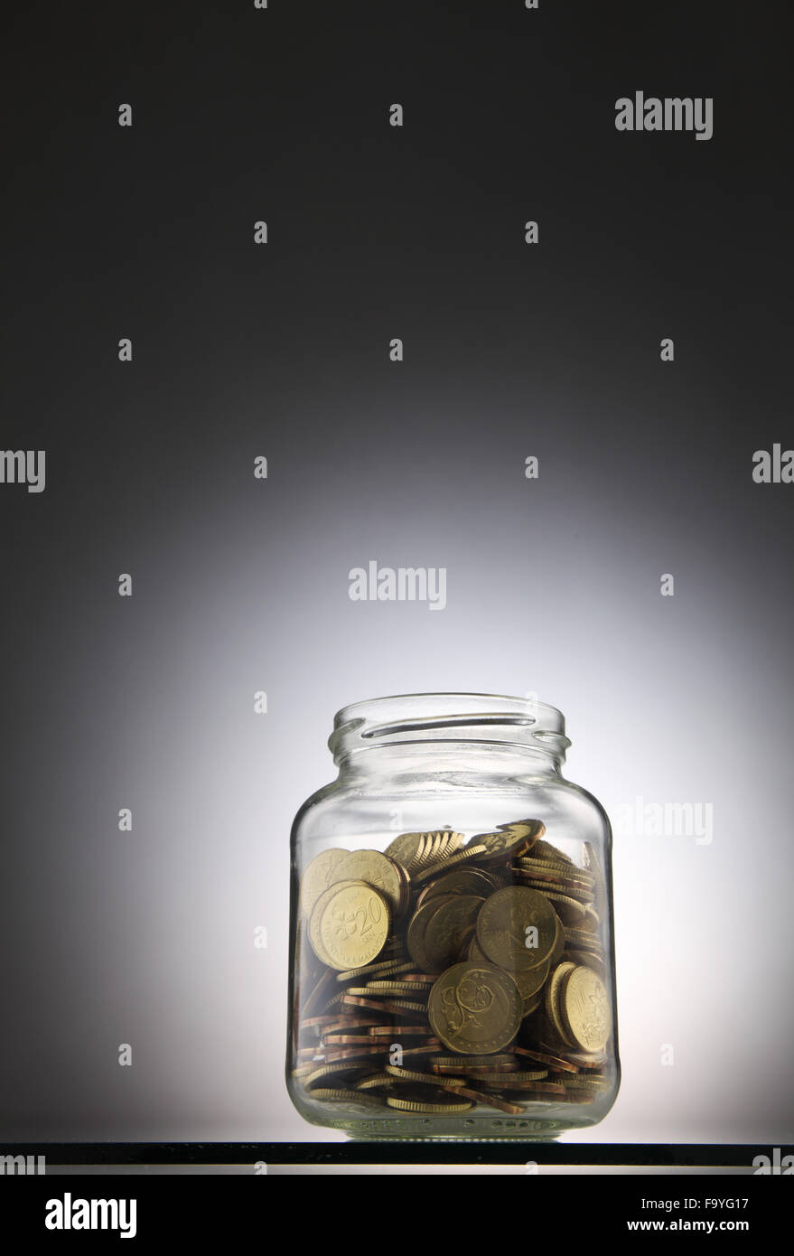 Geld oder Münzen in das rettende Glas Stockfoto