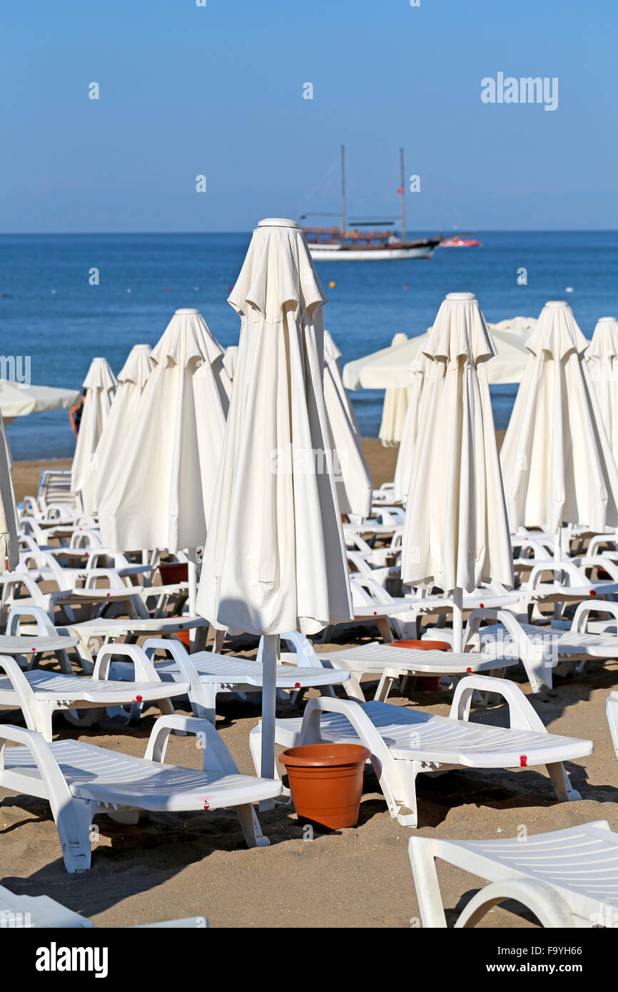 Schöne Liegestühle mit Sonnenschirmen am Strand Stockfoto