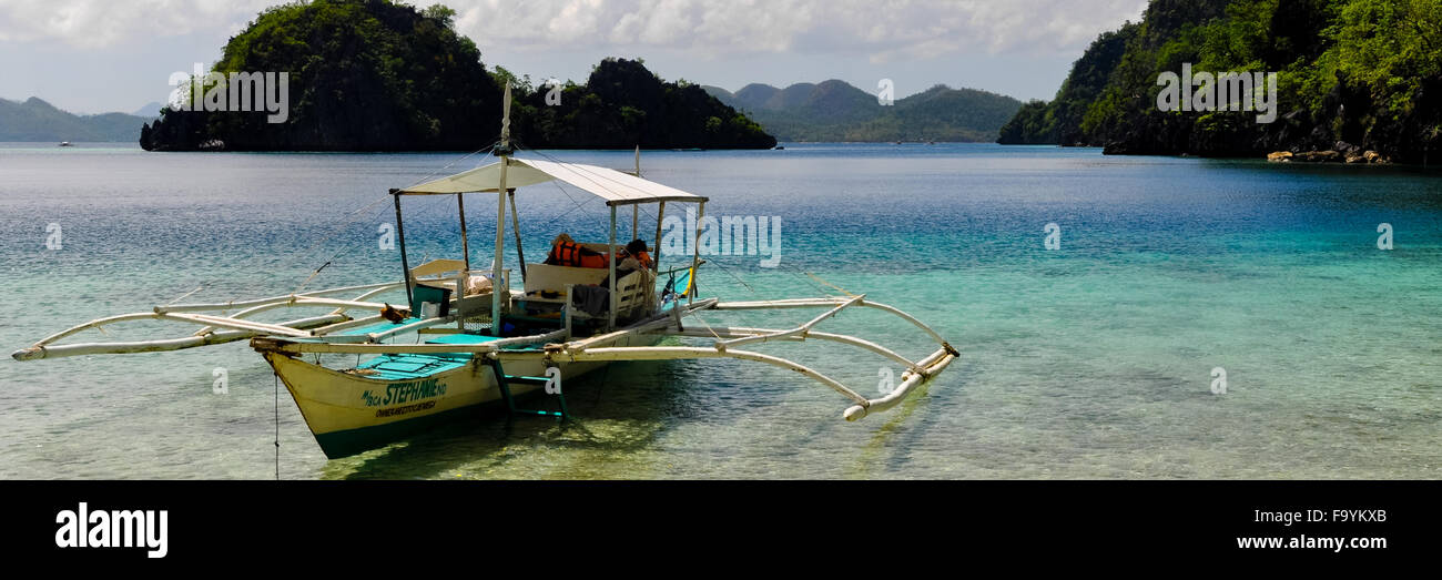 Traditionelle philippinische Holzboot in einer blauen Lagune mit kristallklarem Wasser auf der tropischen Insel Stockfoto