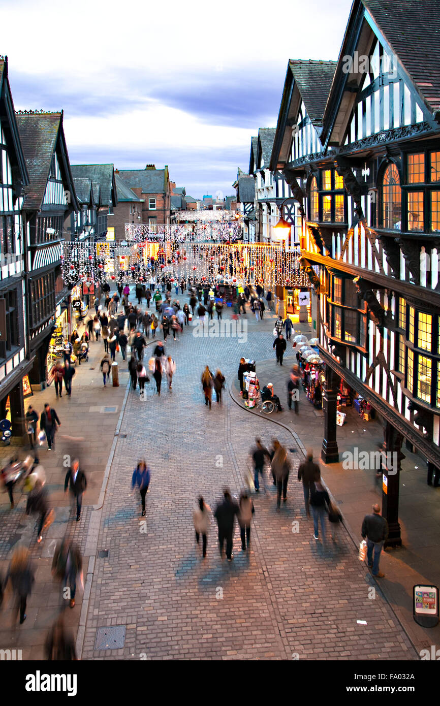 Straßenszene von Chester England mit Weihnachtsbeleuchtung und Menschen beim Einkaufen Stockfoto