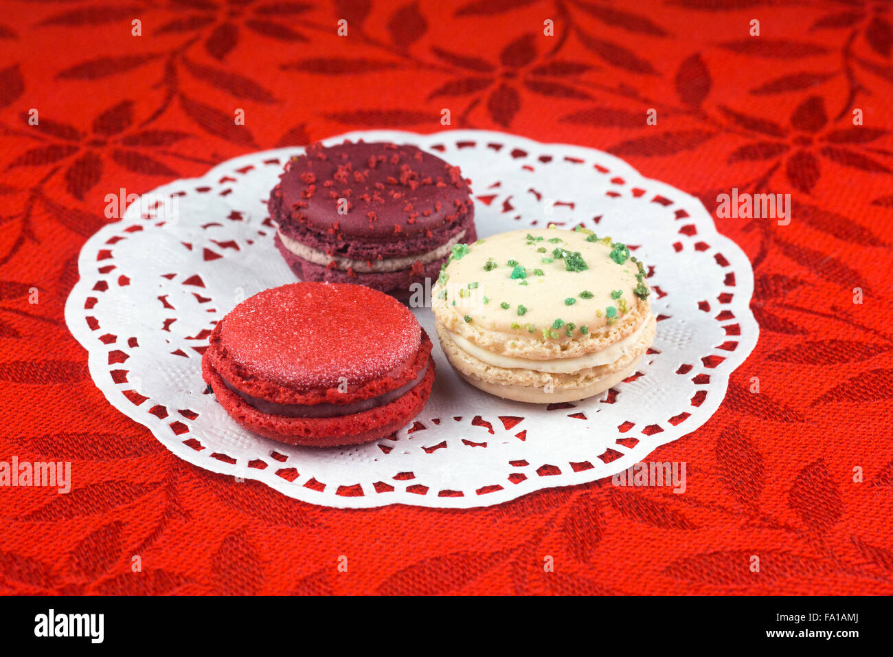 Weihnachten Macarons, Vanille, Basilikum, Matt Cranberry und Glühwein Weine Aromen auf roten Tischdecke Stockfoto