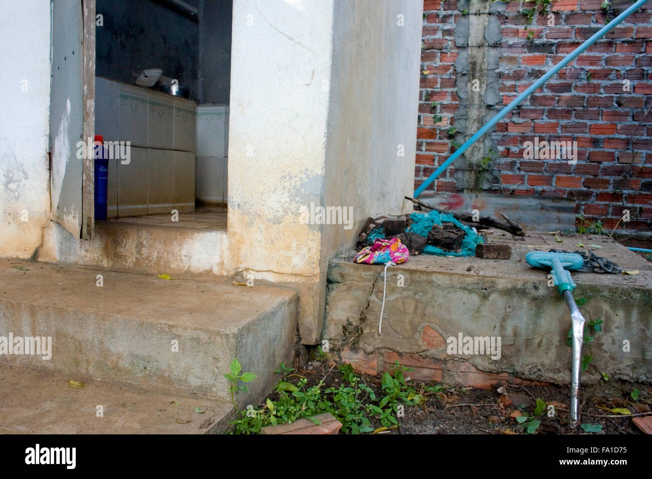 Eine gebrochene Mop und verschiedene Kleidungsstücke ausruhen in der Nähe ein Bad an einer englischen Schule in Ou Reang Ov Bezirk, Kambodscha. Stockfoto