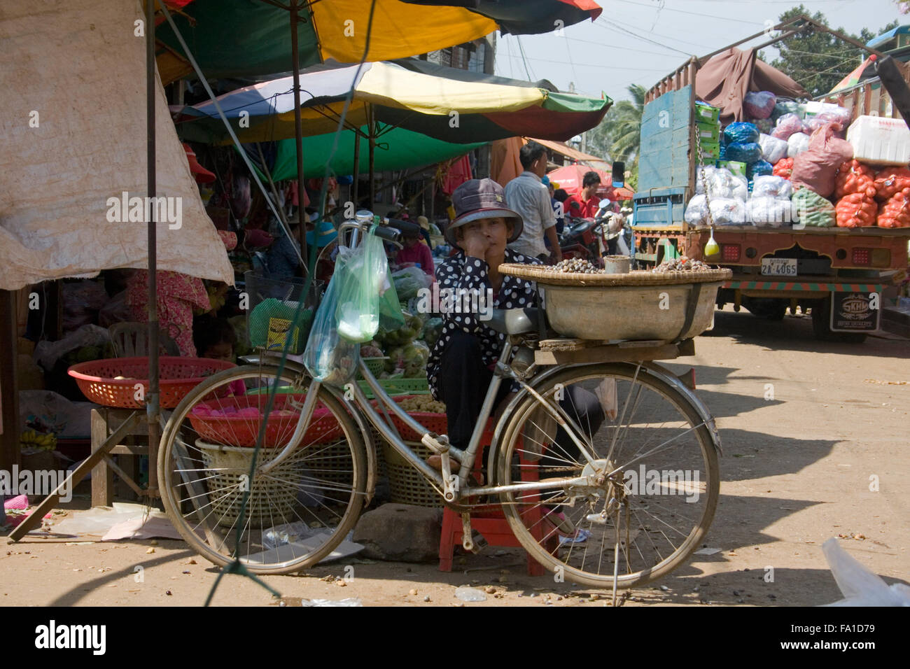 Eine Frau sitzt in der Nähe ein Fahrrad Verkauf von Schnecken am Hauptmarkt in Ou Reang Ov Bezirk, Kambodscha. Stockfoto