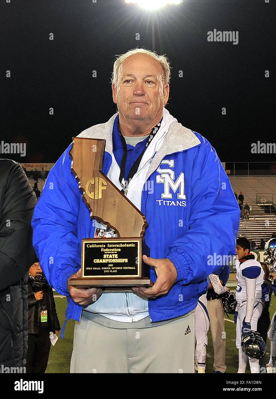 Sacramento, CA. 19. Dezember 2015. San Marino Head Coach Mike Hobbie mit den Zweitplatzierten Trophäe nach der Varsity Prep Football Open kleine Schulen Championship Spiel San Marino Vs zentrale katholische an der Sacramento State University in Sacramento, besiegt California.Central katholischen San Marino 56-21.Louis Lopez/CSM/Alamy Live News Stockfoto