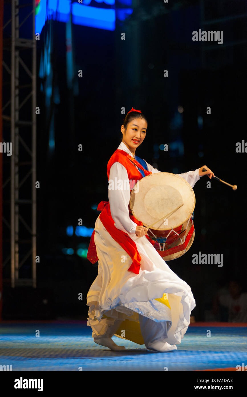 Schöne koreanische Frau tanzen, traditionelle Janggu Schlagzeug in weißen und roten Hanbok auf einer Open-Air-Nacht Sommer performance Stockfoto