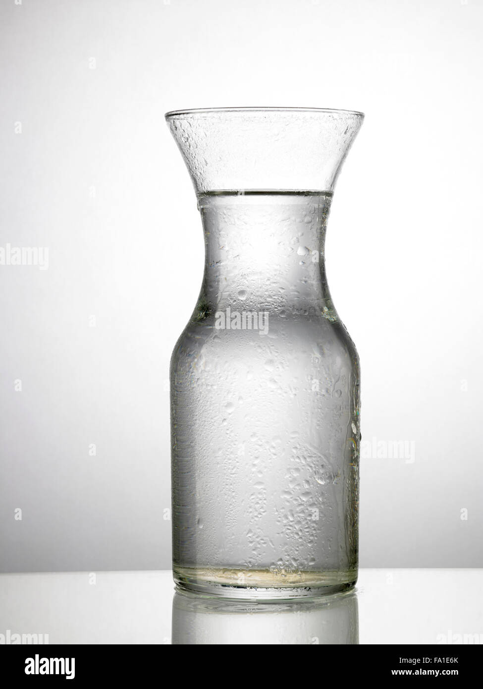Glas Wasser auf Glastisch Stockfoto