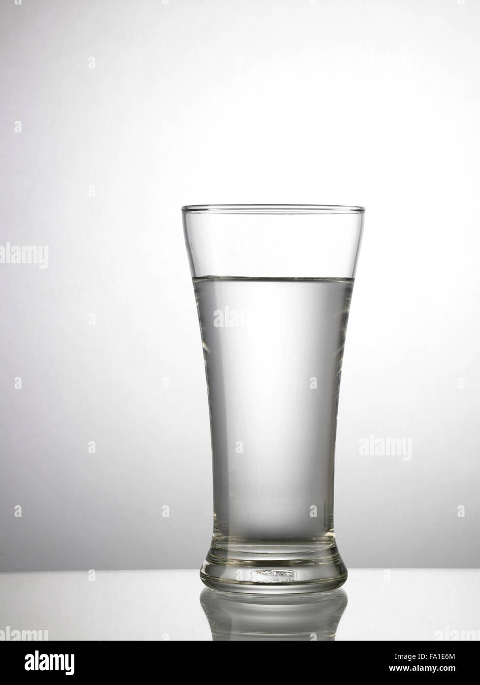 Glas Wasser auf Glastisch Stockfoto