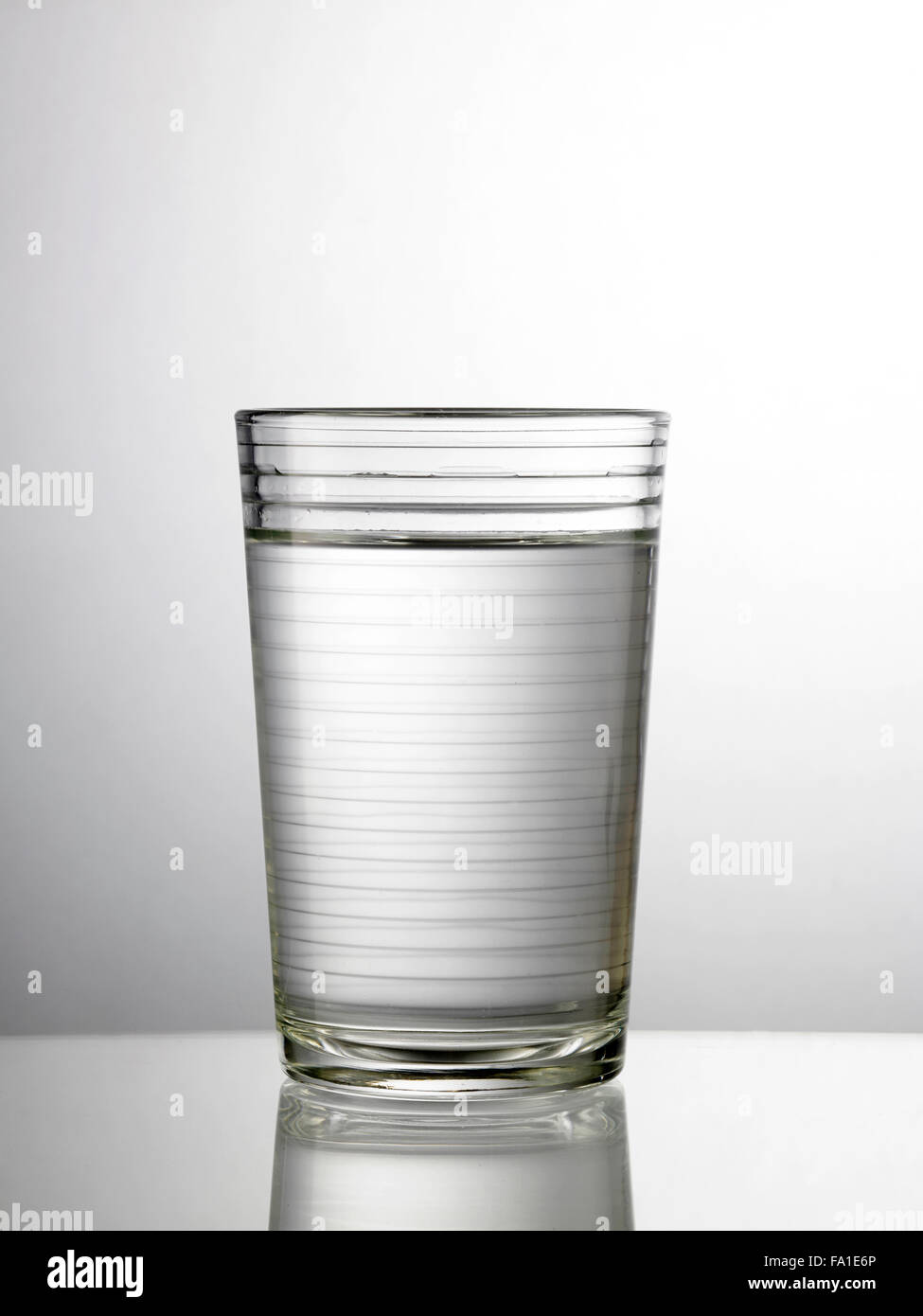 Glas Wasser auf Glastisch Stockfoto