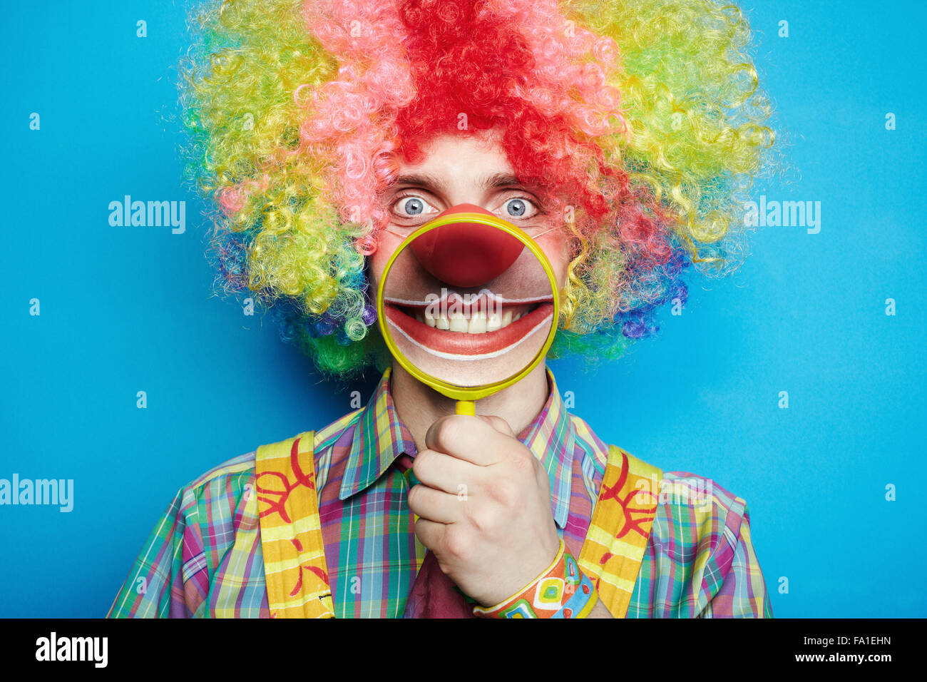 Porträt fröhliche Clown mit dem Lächeln auf blauem Hintergrund Stockfoto