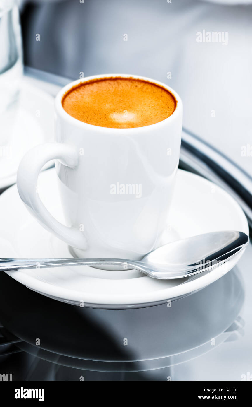 Espresso-Kaffeemaschine volle Tasse und Untertasse auf Nachttisch closeup Stockfoto