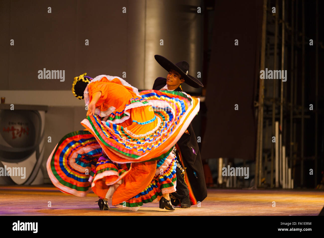 Tänzerin biegen und drehen ihren Körper in orange wirbeln und flatternde Kleidung bei mexikanischen Jalisco Sones-Tanz-show Stockfoto