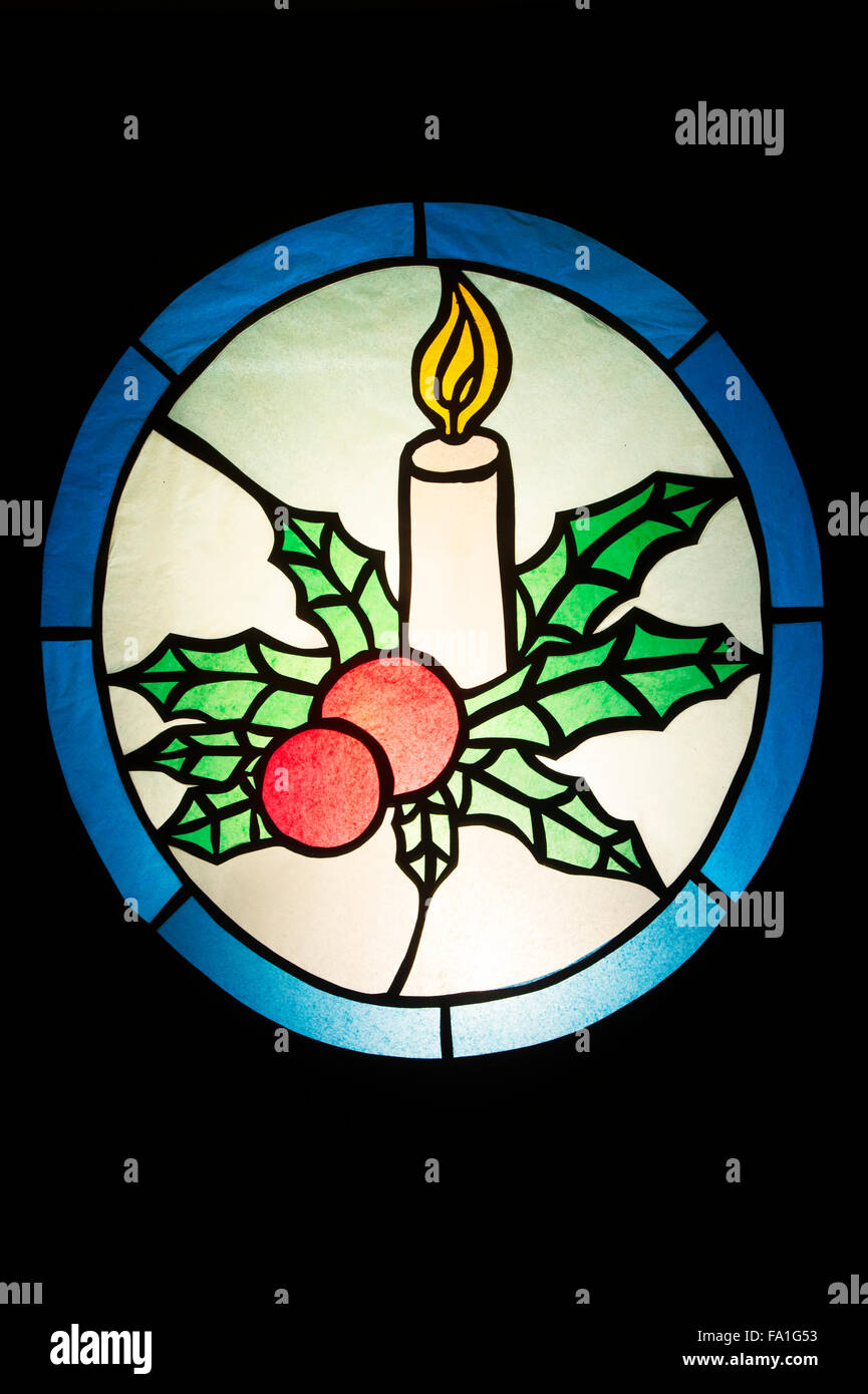Festliche Weihnachten Schaufenster. Kerze und Holly. Northamptonshire, England Stockfoto