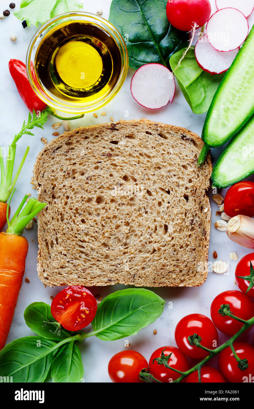 Scheibe ein Vollkornbrot und gesunde Bio-Gemüse für die Herstellung von Sandwiches. Gesund essen oder Kochen Konzept. Stockfoto