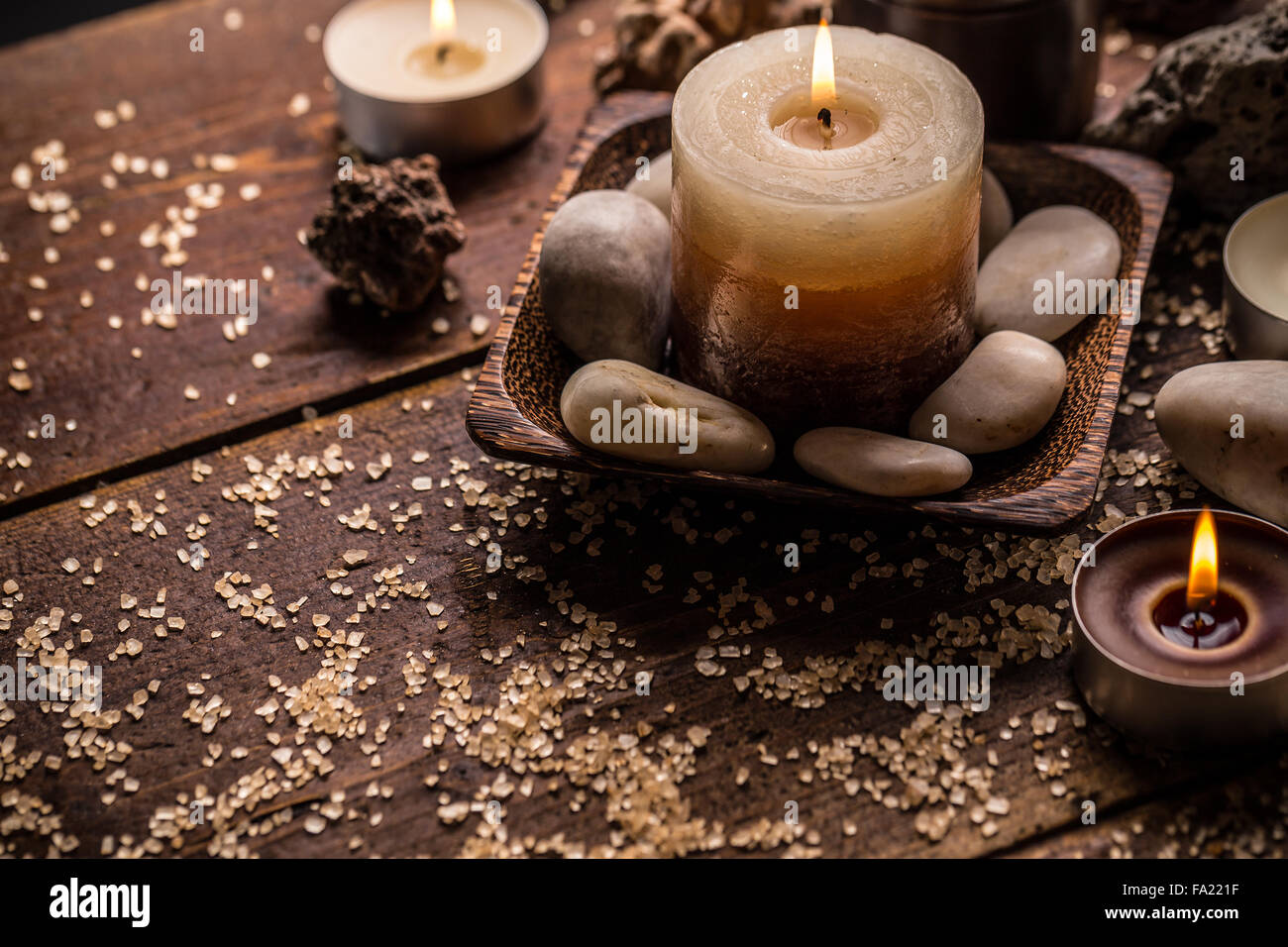Brennende Kerzen auf Holzuntergrund Stockfoto