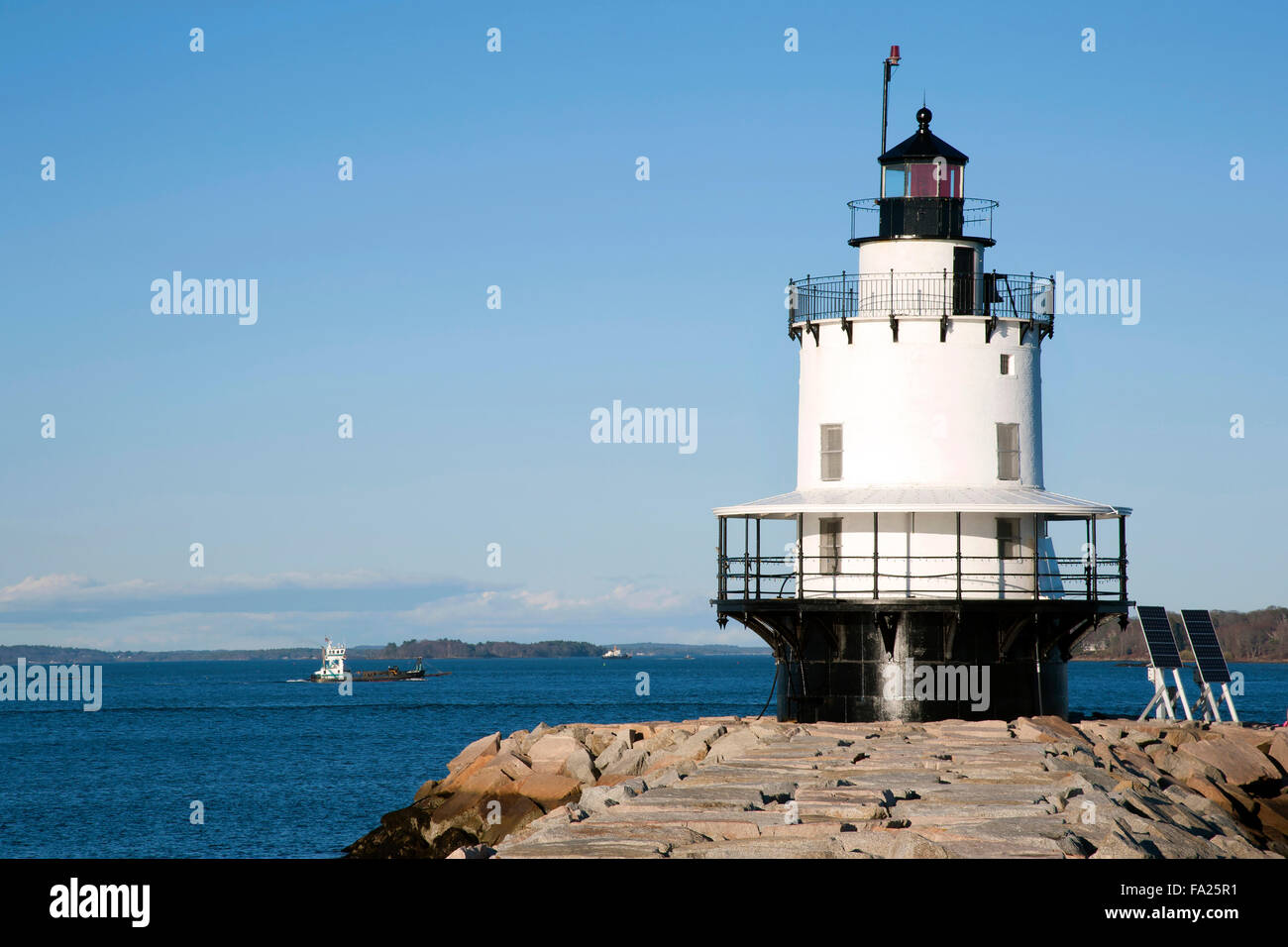 Spring Point Lighthouse guiding Boot in den Hafen von Portland in Maine an einem Sommertag. Das Design der Rundumleuchte Rundumleuchte ähnelt einer Zündkerze. Stockfoto