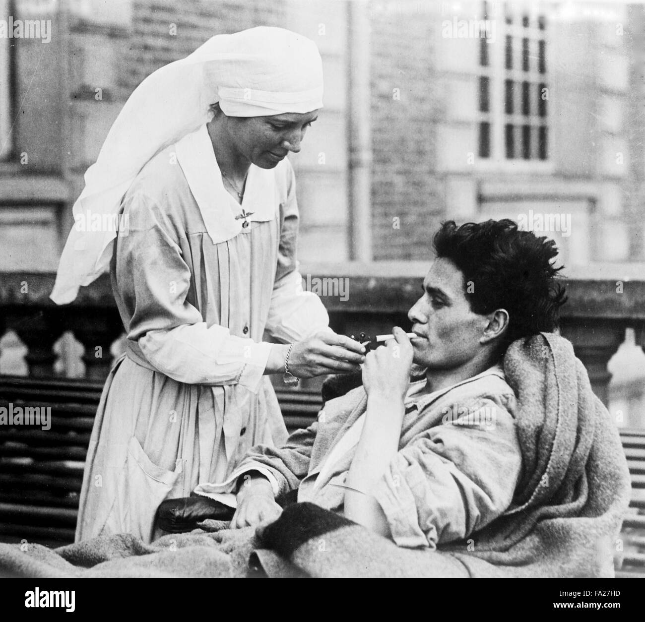 Krankenschwester gibt ein Patient eine Zigarette, historisches Bild einer Krankenschwester, die ein Patient Zigarette Stockfoto