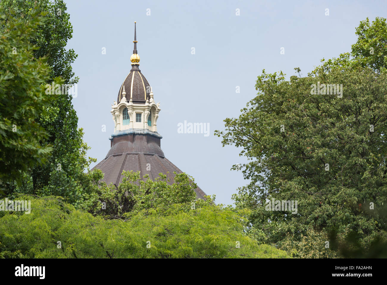 Turm von Antwerpen Hauptbahnhof gesehen durch Bäume in einem Stadtpark Stockfoto