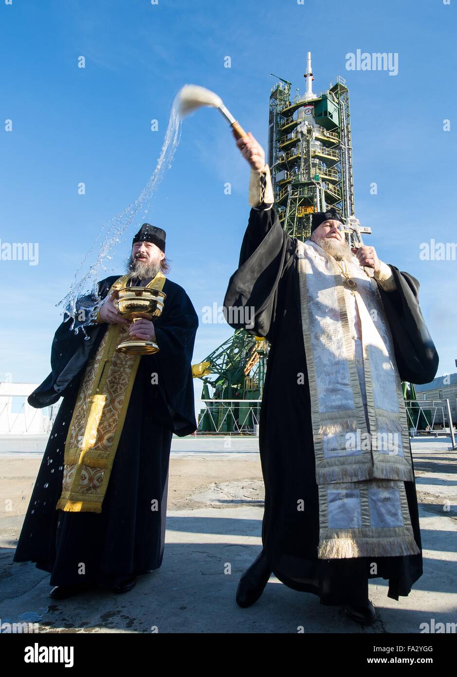 Ein russisch-orthodoxer Priester segnet das Raumschiff Sojus TMA - 19M auf der Startrampe in Baikonur Kosmodrom 14. Dezember 2015 in Baikonur, Kasachstan. Die Expedition 46 Besatzung einschließlich Sojus Commander Yuri Malenchenko, startet US-amerikanischer Astronaut Tim Kopra und Großbritannien Tim Peake der ESA zur internationalen Raumstation ISS für einen sechsmonatigen Aufenthalt. Stockfoto