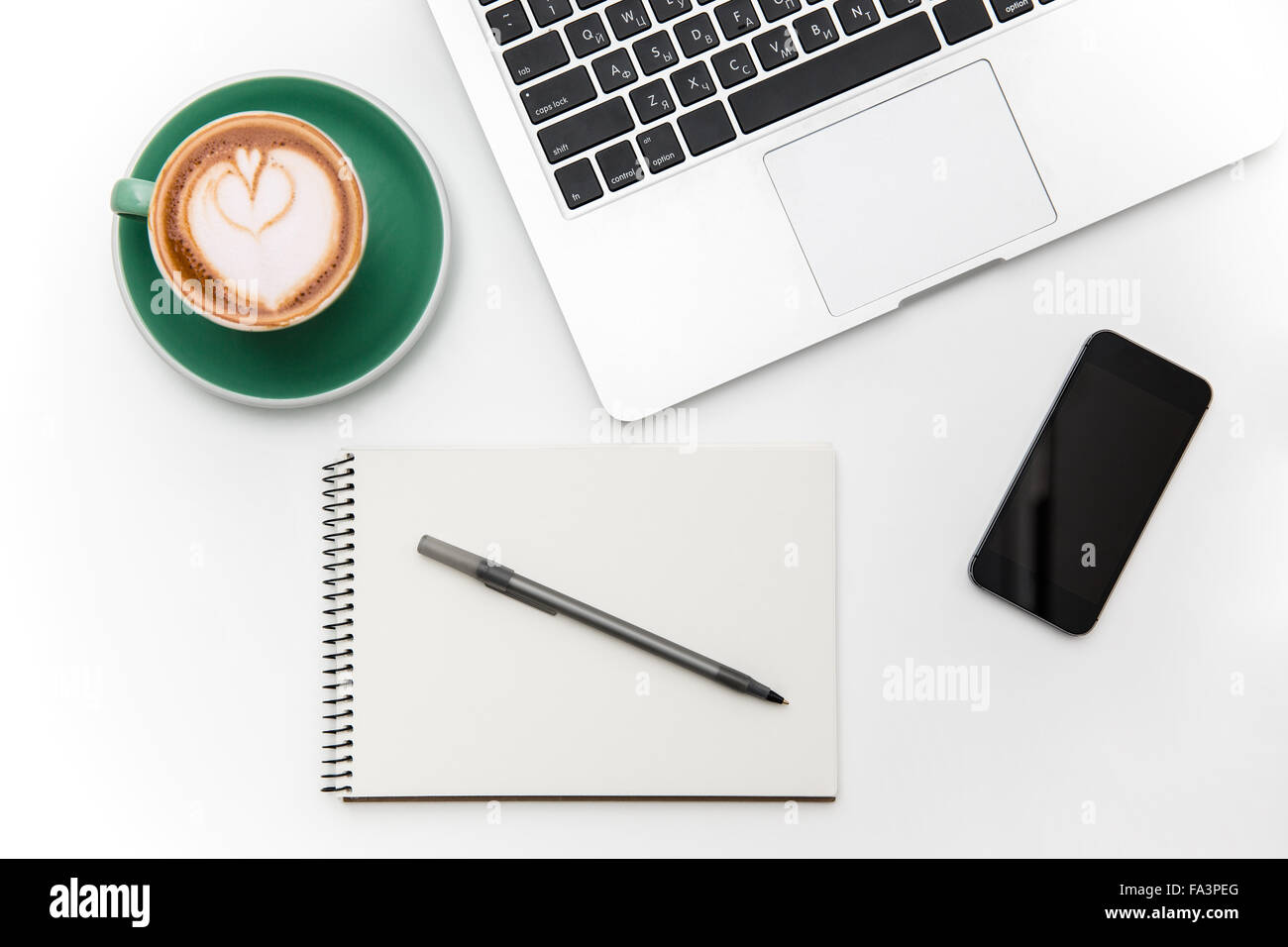 Draufsicht der leeren Bildschirm Handy, Laptop, Tasse Kaffee, Notizblock und Stift isoliert auf weißem Hintergrund Stockfoto