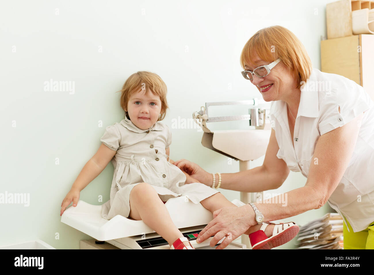 Kinderarzt wiegen das Babymädchen in Klinik Stockfoto