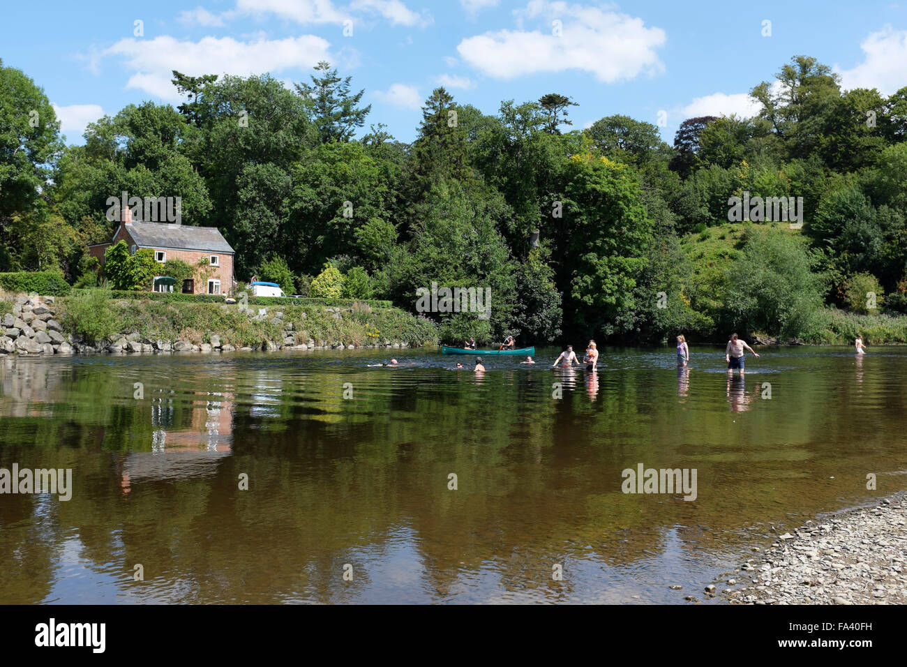 Menschen, die genießen, Paddeln und Baden im Fluss Wye am Stadtrand von die Bücherstadt Hay-on-Wye, Powys, Wales Stockfoto