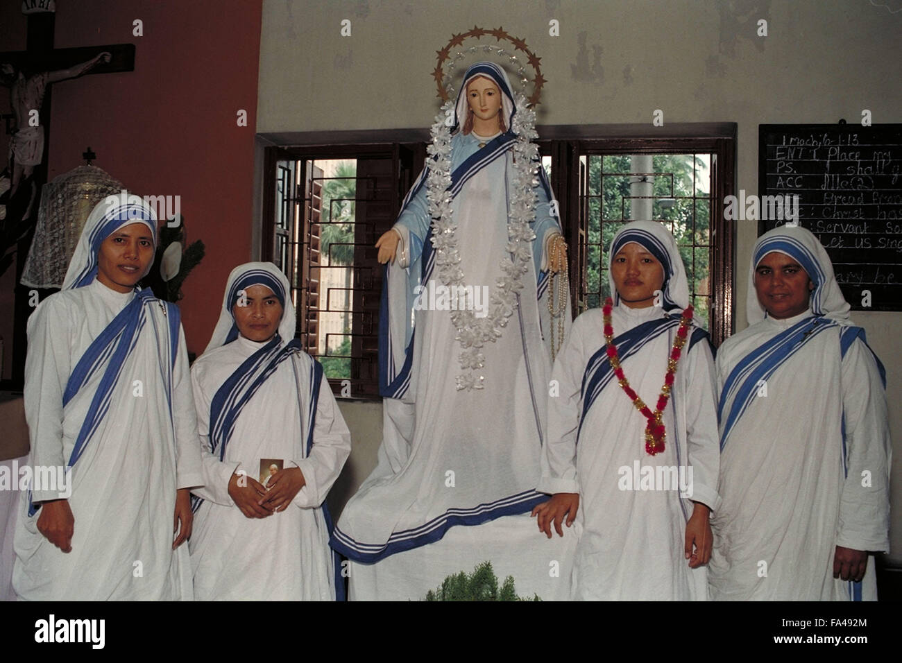 Missionarin der Nächstenliebe Schwestern posiert mit Statue der Maria von Fatima Stockfoto