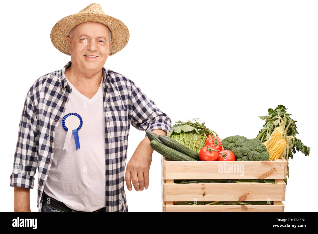 Reifen Bauer mit einem Award-Abzeichen auf seinem Hemd, stützte sich auf eine Kiste voll mit Gemüse isoliert auf weißem Hintergrund Stockfoto