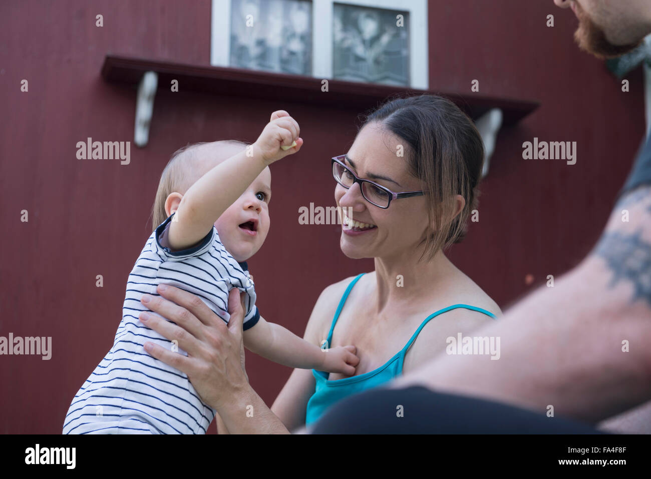 Baby Junge in den Armen seiner Mutter anbietennahrung zu seinem Vater, München, Bayern, Deutschland Stockfoto