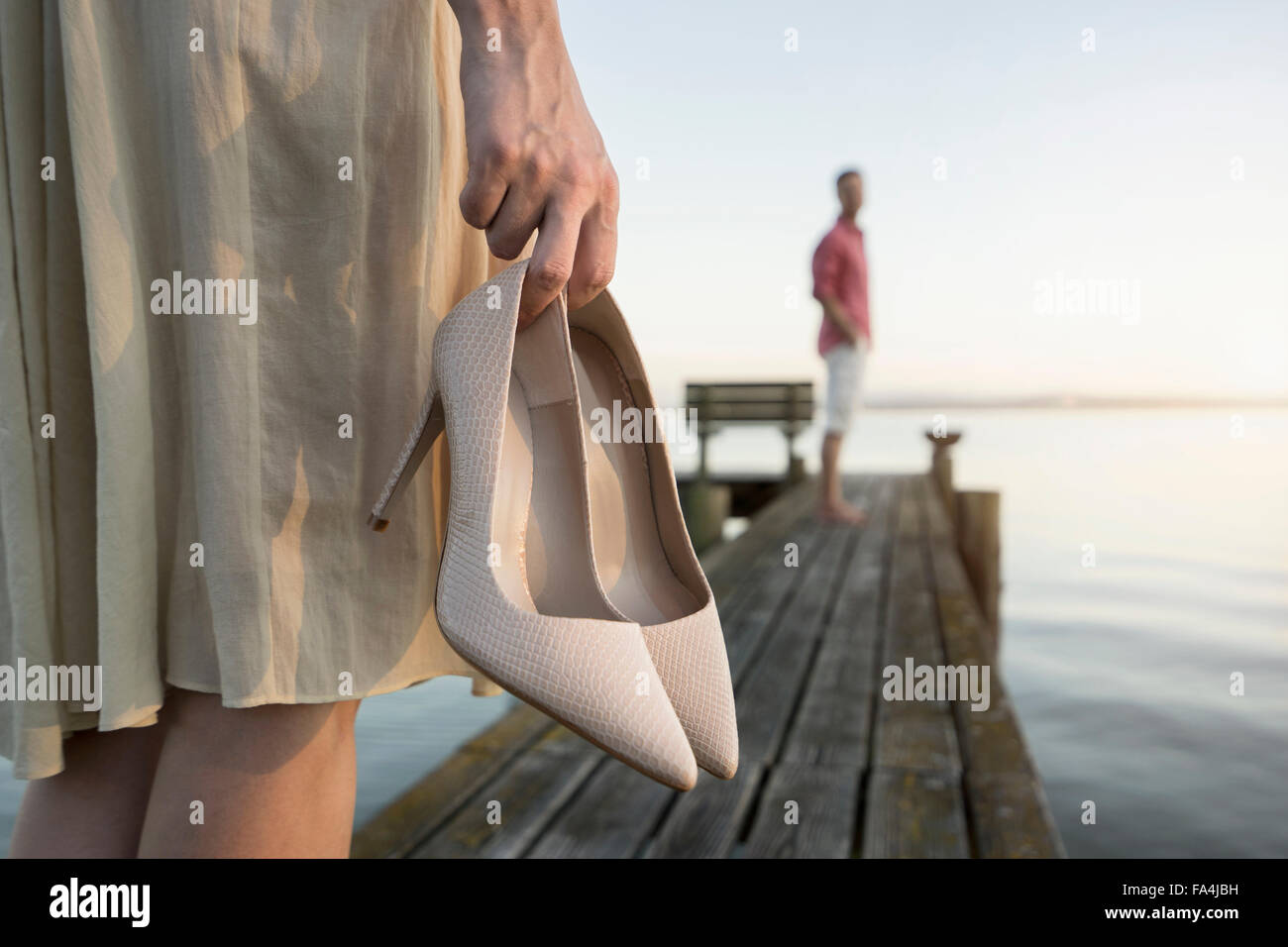 Reifer Mann wartet auf seine Frau am Pier am See, Bayern, Deutschland Stockfoto