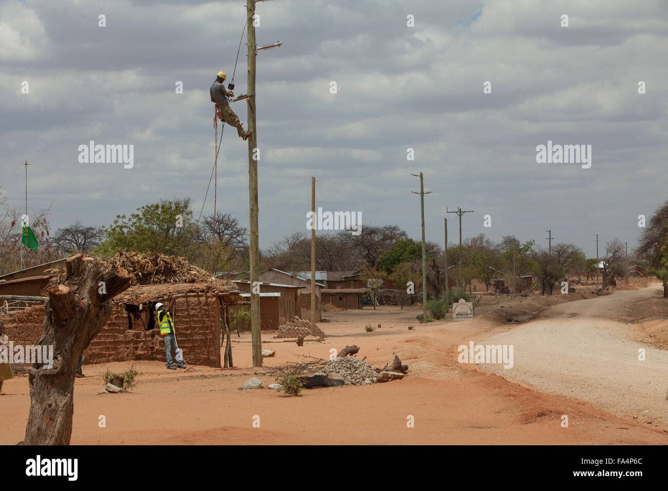 Arbeitnehmer eine Zeichenfolge neue Stromkabel in einem ländlichen Dorf in der Nähe von Dodoma, Tansania, Ostafrika. Stockfoto