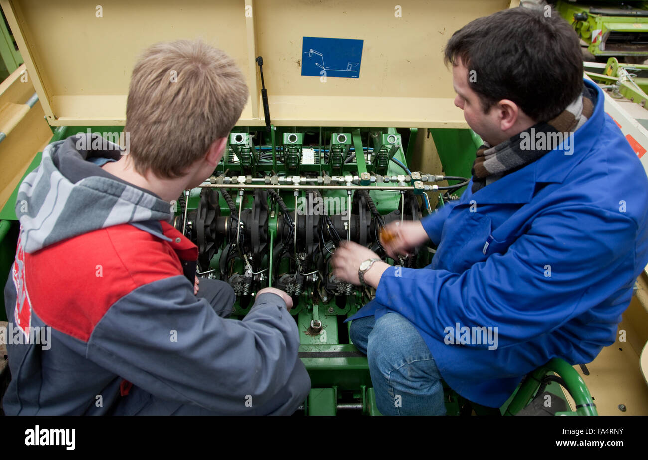 Praktische Ausbildung in der Mechatronik. Unterricht Lehrer erklärt die Mechanik bei einer Erntemaschine. Stockfoto