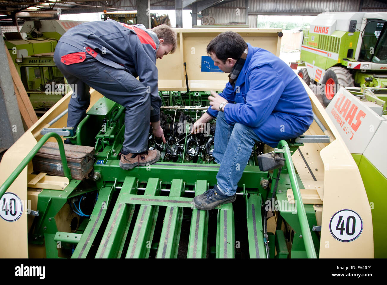 Praktische Ausbildung in der Mechatronik. Unterricht Lehrer erklärt die Mechanik bei einer Erntemaschine. Stockfoto