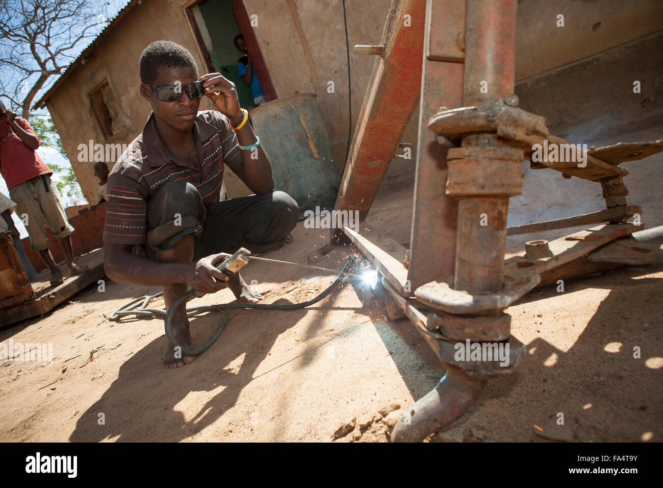 Ein Mann betreibt eine elektrisch betriebene Schweißen Maching in Dodoma, Tansania, Ostafrika. Stockfoto