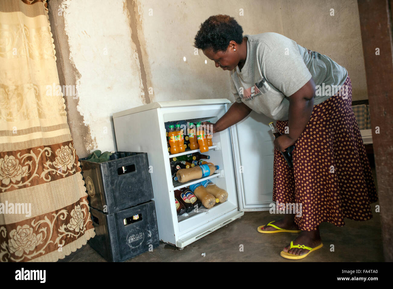 Eine Frau benutzt einen elektrisch betriebener Kühlschrank in Dodoma, Tansania. Stockfoto