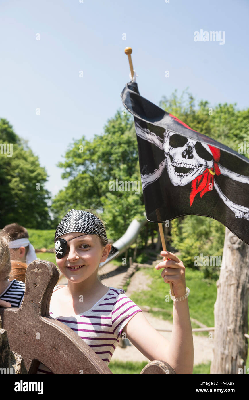 Porträt eines Mädchens verkleidet als Pirat mit Piratenflagge in Abenteuerspielplatz, Bayern, Deutschland Stockfoto