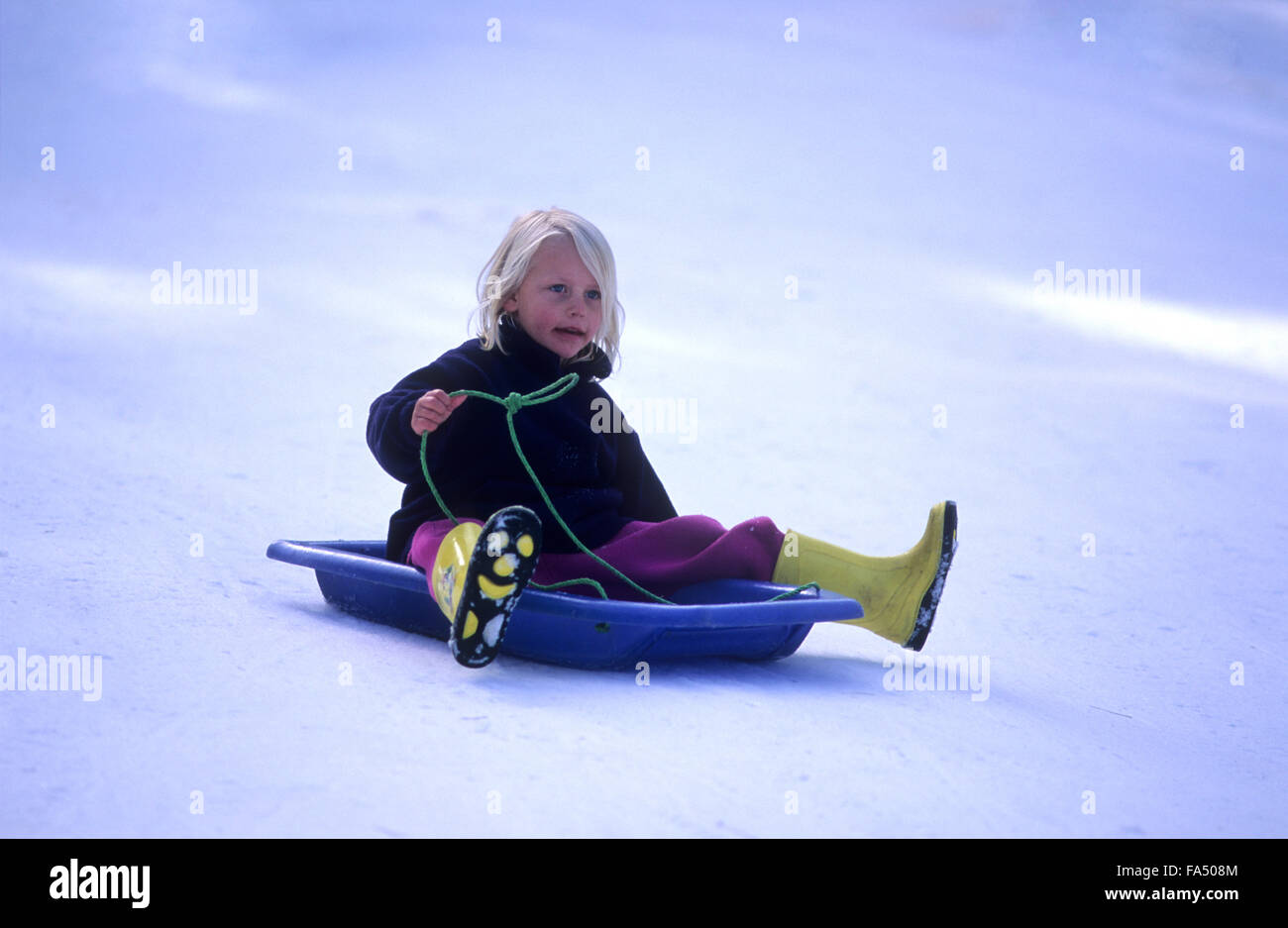 Kinder, Winter, Rodeln in Schneefelder, junges Mädchen über 6 Jahre alt Rodeln. Stockfoto