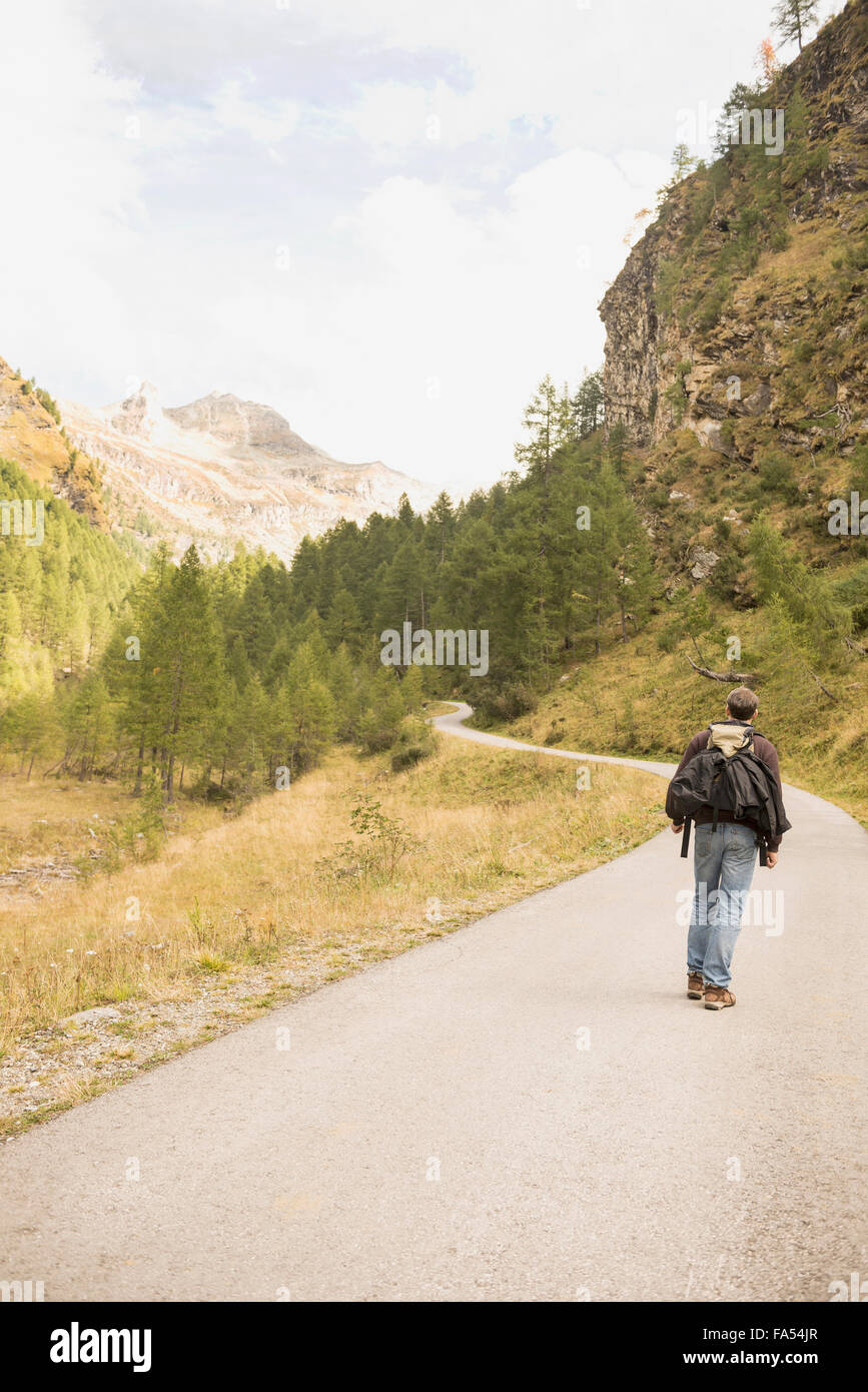 Rückansicht des Reifen Wanderer zu Fuß auf Mountain Road, Österreichische Alpen, Kärnten, Österreich Stockfoto